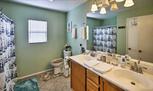 This full bathroom features a shower/tub comb