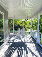 Porch swing on wrap around porch of fully furnished house