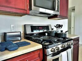 Fully stocked kitchen with pans and dishes