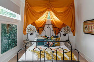 Bedroom with gold drapes and vintage bed
