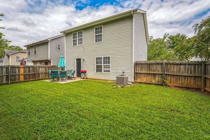 Fenced yard with BBQ grill.