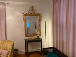 Grand mirror over marble table greets you.