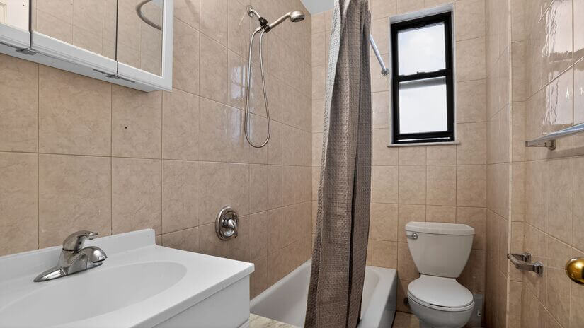 Clean bathroom with bathtub and shower setup