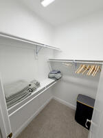 walk-in closet with hangers and extra linens