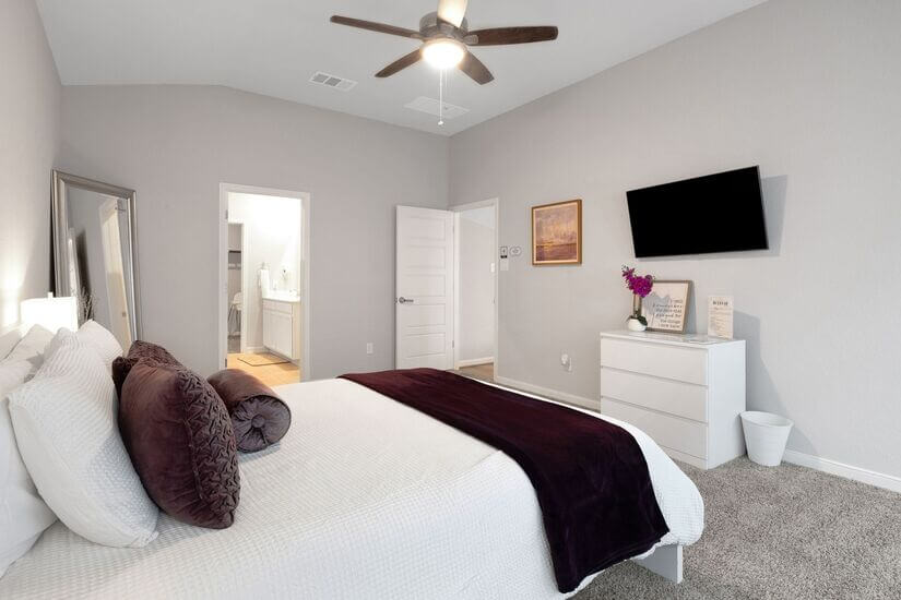 Master bedroom with Smart TV and private bath access.