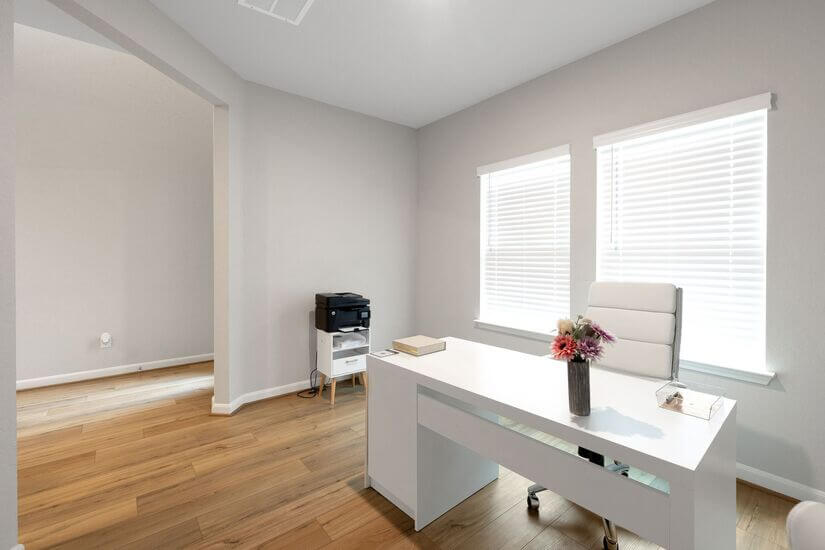 Home office with desk, ergonomic chair & laser printer.