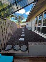 Fenced side yard with lava-rock path