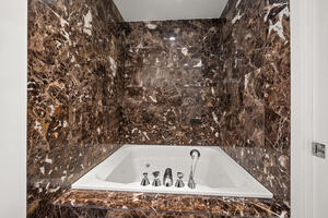 Jetted bathtub with veined marble surround