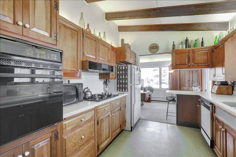 Gallery style kitchen with antique bottles