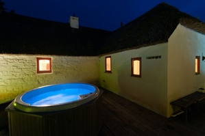 Relax in the hot tub over looking the rushing stream below..