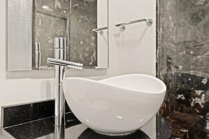 Vessel sink and richly veined marble bathroom