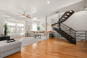 Living room, wood floors and open staircase