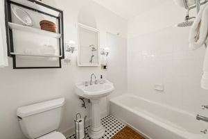 Bathroom with Tub, Vanity, and Storage Shelving