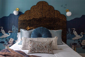 designer headboard + warm tones in bedroom